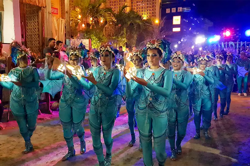 Weibliche Tanzgruppe in türkisfarbenen Kleidern beim Karneval auf der Insel Holbox