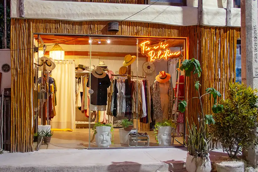 Shop window of the Mayik Boutique in Holbox with clothing and an eye-catching sign.